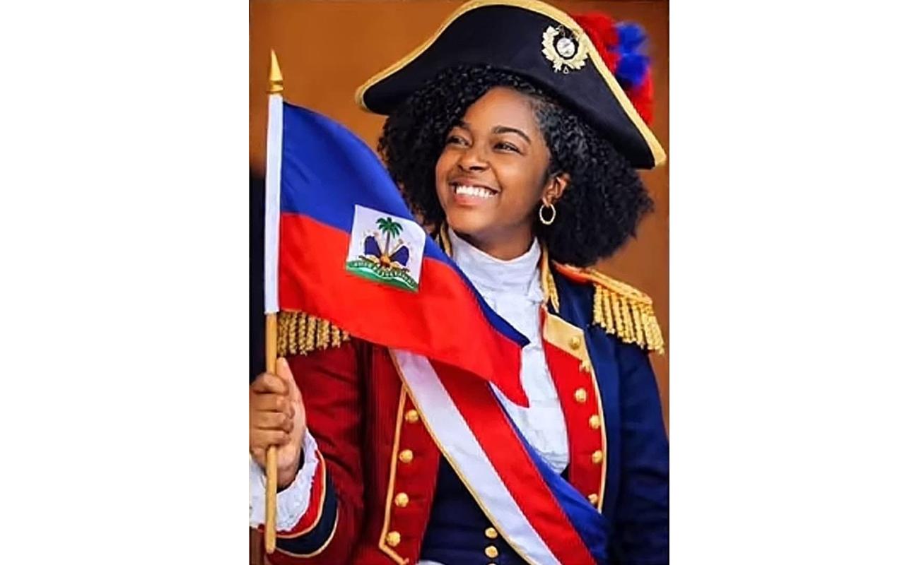 Jeune femme haïtienne en costume historique tenant le drapeau d’Haïti et souriante, représentant la fierté nationale et la réussite internationale.