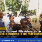 Mission technique du Fonds national de l’Éducation évaluant l’École nationale de Marblanche à Anse-à-Pitres, Haïti, le 6 mai 2026. Bâtiments scolaires précaires entourés d’élèves et de membres de la communauté locale.